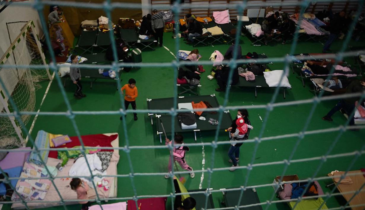 Pengungsi Ukraina terlihat di pusat pengungsian sementara di sekolah dasar setempat di Tiszabecs, Hongaria timur, 28 Februari 2022. Warga Hungaria bergegas ke perbatasan Ukraina untuk membantu pengungsi yang melarikan diri dari invasi Rusia. (Attila KISBENEDEK/AFP)