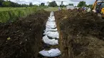 Tim forensik menguburkan secara massal sekelompok imigran yang tewas saat mencoba menyeberangi Celah Darien di Pemakaman Guayabillo, Agua Fria, Panama, 30 September 2021. Celah Darien berupa lembah dan rawa-rawa di Amerika Tengah yang memutus Jalan Pan Amerika. (AP Photo/Arnulfo Franco)