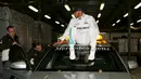 Pembalap Mercedes F1 Lewis Hamilton duduk di atas mobil menunggu konferensi pers setelah kualifikasi di Australian Formula One Grand Prix di Melbourne (19/3). Juara F1 musim lalu itu mencatatkan waktu 1 menit 23,837 detik. (REUTERS/Jason Reed)