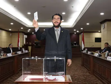 Hakim Konstitusi Anwar Usman menunjukkan surat suara saat pemilihan Ketua Mahkamah Konstitusi (MK) di Jakarta, Senin (2/3). Anwar Usman terpilih sebagai Ketua MK periode 2018-2020. (Liputan6.com/Angga Yuniar)