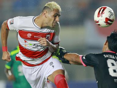 Bek Madura United, Jaimerson Da Silva Xavier (kiri) duel udara dengan kiper Persebaya Surabaya, Satria Tama, dalam pertandingan Babak Penyisihan Piala Menpora 2021 Grup C di Stadion Si Jalak Harupat, Bandung, Minggu (28/3/2021). (Foto: Bola.com/M Iqbal Ichsan)