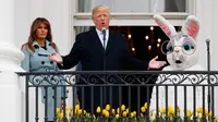 Presiden AS Donald Trump didampingi istirnya Melania Trump dan badut Kelinci Paskah berbicara dari Truman Balcony saat perayaan Easter Egg Roll di Gedung Putih, Washington (4/2). (AP Photo / Carolyn Kaster)