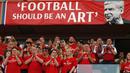 Suporter saat memberikan salam kepada Arsene Wegner dekat spanduk potongan ungkapan sang pelatih di Emirates Stadium, London, (6/5/2018). Arsene Wegner mengumumkan mundur sebagai pelatih setelah 22 tahun bersama Arsenal. (AFP/Adrian Dennis)