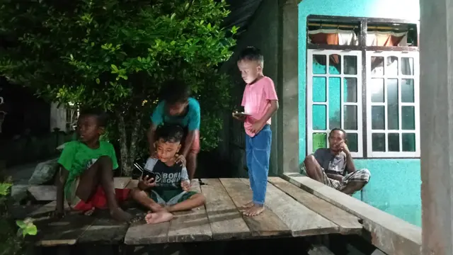 Aktivitas anak-anak warga Desa Ujir pada malam hari setelah pembangunan PLTS Terpadu.