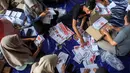 Pekerja melipat surat suara pemilihan presiden yang dijadwalkan pada 14 Februari di Gudang Komisi Pemilihan Umum (KPU) Yogyakarta, Bantul, Kamis (4/1/2024). (DEVI RAHMAN/AFP)