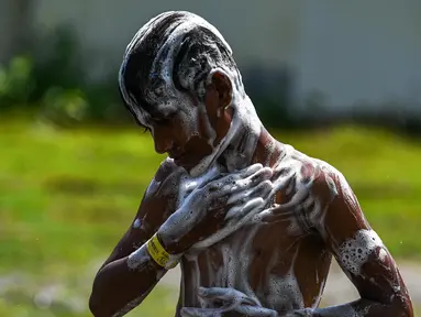 Seorang pengungsi Rohingya mandi di tempat penampungan sementara di Ladong, provinsi Aceh, Kamis 24 Februari 2023. Sedikitnya 69 pengungsi Rohingya mendarat di pantai barat Indonesia pada 16 Februari lalu dengan sebuah perahu kayu. (CHAIDEER MAHYUDDIN/AFP)