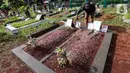 Pengurus makam membersihkan makam Vanessa Angel dan Bibi Ardiansyah di TPU Taman Makam Islam Malaka Blok D, Pesanggrahan, Jakarta, Senin (7/02/2022). Pada Perda Jakarta No.3/2007 Pasal 26 pemindahan dan penggalian jenazah sebaiknya dilakukan satu tahun setelah dimakamkan. (Liputan6.com/Fery Pradolo)