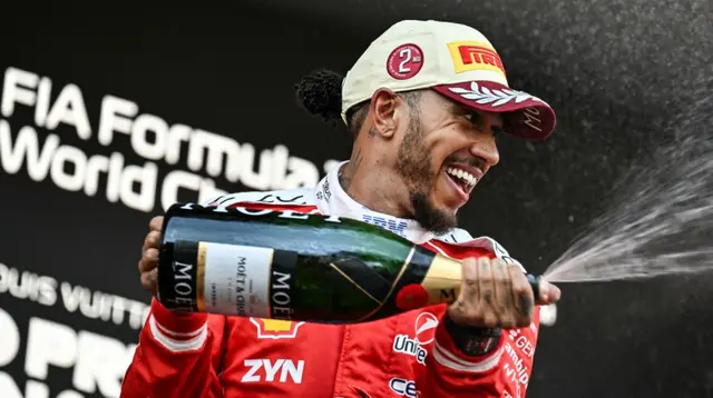 Pembalap Ferrari asal Inggris, Lewis Hamilton, merayakan di podium setelah berkompetisi di Grand Prix F1 Monako di sirkuit jalan raya Monako di Monako pada 7 Juni 2026. (Andrej ISAKOVIC/AFP)