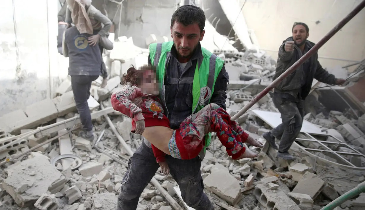Petugas mengevakuasi seorang anak yang terluka akibat serangan udara di kawasan Douma yang dikuasai para pemberontak di Damaskus, Suriah (7/11). Serangan ini memakan korban warga sipil yang sebagian besar anak-anak. (Reuters/Bassam Khabieh)
