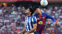 Gelandang Spanyol Barcelona #27, Pedro Fernandez "Dro", dan penyerang Portugal Real Sociedad #11, Goncalo Guedes, bersaing untuk mendapatkan sundulan selama pertandingan Liga Spanyol antara FC Barcelona dan Real Sociedad di Estadi Olimpic Lluis Companys di Barcelona pada 28 September 2025. (Josep LAGO/AFP)