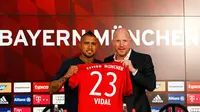 Gelandang Cile, Arturo Vidal, bersama Matthias Sammer berpose dengan jersey Bayern Munchen di Allianz Arena, Munchen, Jerman (28/7/2015). Bayern Munchen resmi mengontrak Vidal dengan kontrak selama empat musim. (Reuters/Michaela Rehl)