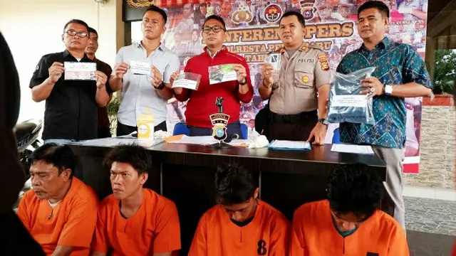 Personel Polresta Pekanbaru memperlihatkan barang bukti yang disita dari kasus penipuan dukun palsu.
