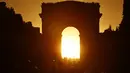 Foto yang diambil pada 2 Agustus 2022 menunjukkan Arc de Triomphe saat matahari terbenam, di Paris. Peristiwa yang dikenal sebagai "Paris Henge" ini terjadi dua kali setahun. (Photo by Stefano RELLANDINI / AFP)