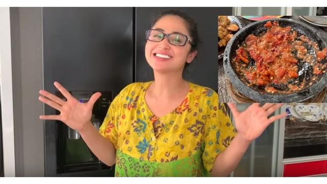 Saat memasak untuk suami dan anaknya, Depe tetap terlihat cantik dengan daster bermotif bunga.