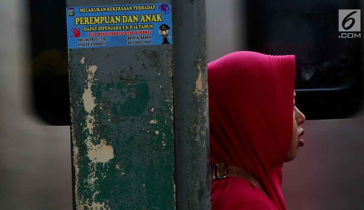 Stiker informasi pengaduan kekerasan ditempel di sekitar Stasiun Tanah Abang, Jakarta, Kamis (21/12). Stiker ini juga bertuliskan informasi tentang pengaduan ketika terjadi kekerasan pada wanita dan anak. (Liputan6.com/JohanTallo)