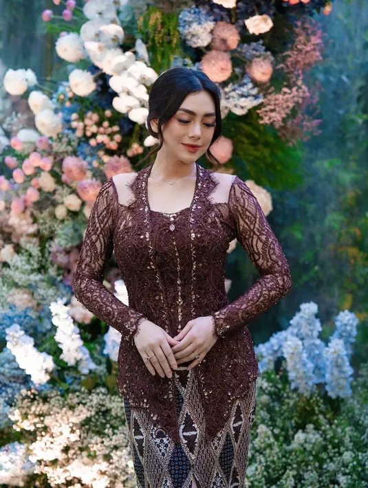 Kebayanya hadir dengan bahan brokat dan aksen payet yang menawan.