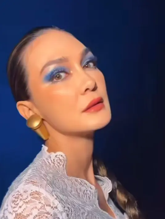 MUA Kiky Lutan mengaplikasikan eyeshadow biru pada riasan mata Luna Maya, dengan lipstik warna merah maroon.  [@lunamaya]