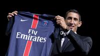 Gelandang baru Paris Saint Germain, Angel Di Maria memegang jersey barunya saat perkenalan di Paris, Prancis, Kamis (6/8/2015). Di Maria dikontrak PSG dengan durasi empat musim. (AFP Photo/Kenzo Tribouillard)   