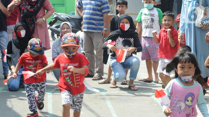 Anak-anak dengan menggunakan masker mengikuti lomba tujuh belas Agustus di Cinere, Depok, Senin (17/8/2020). Warga di sejumlah kampung di wilayah Jabodetabek tetap melakukan beragam kegiatan lomba memperingati HUT ke-75 Kemerdekaan RI dengan menerapkan protokol kesehatan. (merdeka.com/Arie Basuki)