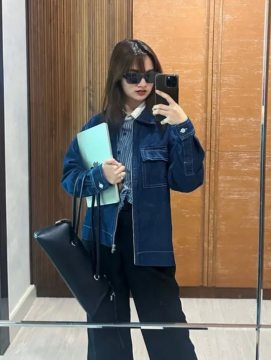 Dalam potret yang diunggahnya, Sabrina Anggraini tampak mengenakan outfit kasual dengan kemeja stripes dan jaket denim. Influencer berusia 29 tahun ini kemudian memadukannya dengan celana kain warna hitam. Meski simpel, penampilannya ini membuatnya tampak santai namun tetap stylish. Penampilannya yang effortless ini semakin mempertegas kesan muda yang dimilikinya. (Liputan6.com/IG/@sabrinaanggraini)