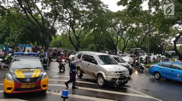 Petugas mengarahkan kendaraan yang melintasi kawasan SCBD usai balkon BEI ambruk, Jakarta, Senin (15/1). Ambruknya atap lobi balkon Bursa Efek Indonesia (BEI) membuat lalu lintas di sekitar SCBD macet. (Liputan6.com/Herman Zakharia)