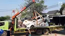 Petugas derek mengevakuasi bangkai mobil kecelakaan maut yang hancur tertindih badan truk muatan tanah di Karawaci, Tangerang, Kamis (1/8/2019). Lima orang penumpang minibus menjadi korban, empat diantaranya meninggal dan satu balita berhasil diselamatkan warga. (Liputan6.com/Pramita Tristiawati)