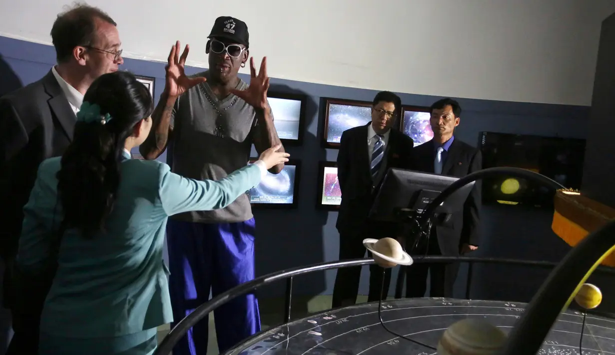 Dennis Rodman berbicara kepada seorang pemandu di Kompleks Sci-Tech di Pyongyang, Korea Utara (14/6). Rodman yang dekat dengan pemimpin Korut Kim Jong Un mulai beraktivitas di Pyongyang. (AP Photo/Kim Kwang Hyon)