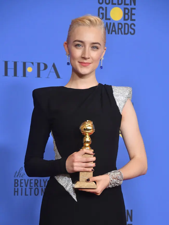 Saoirse Ronan, tampil cantik dengan gaun hitamnya yang berkombinasi warna silver di bagian lengan kirinya, sedangkan di bagian kanan baju ini berlengan panjang dan berwarna hitam. (Foto: AFP)