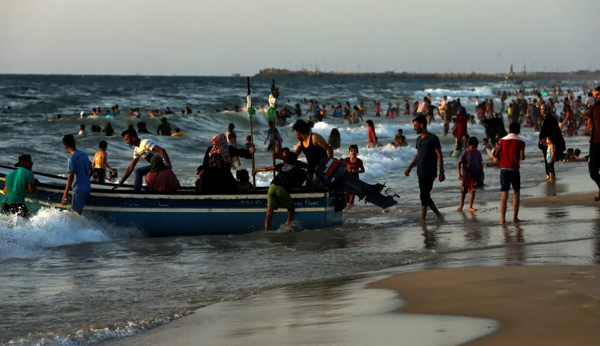 Sejumlah warga Palestina menaiki perahu sambil menikmati pantai Kota Gaza, Jumat (22/6). Panasnya konflik antara Palestina dan Israel membuat penduduk di kawasan Gaza hanya bisa mengandalkan Pantai Gaza sebagai tempat wisata. (AFP PHOTO/MAHMUD HAMS)