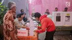 Calon pemilih mendaftar ke petugas Kelompok Penyelenggara Pemungutan Suara (KPPS) saat akan mencoblos di TPS 45 Kebon Pala, Jakarta, Rabu (17/5). TPS tersebut mengambil tema suasana pernikahan adat Jawa untuk menarik minat pemilih dan menekan angka golput. (Liputan6.com/Faizal Fanani)