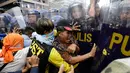 Pengunjuk rasa terlibat bentrok dengan polisi saat menggelar aksi demo di dekat Kedutaan Besar AS di Manila, Filipina (11/11). Mereka menggelar aksi untuk memprotes kunjungan Presiden AS, Donald Trump ke Filipina. (AP Photo/Aaron Favila)