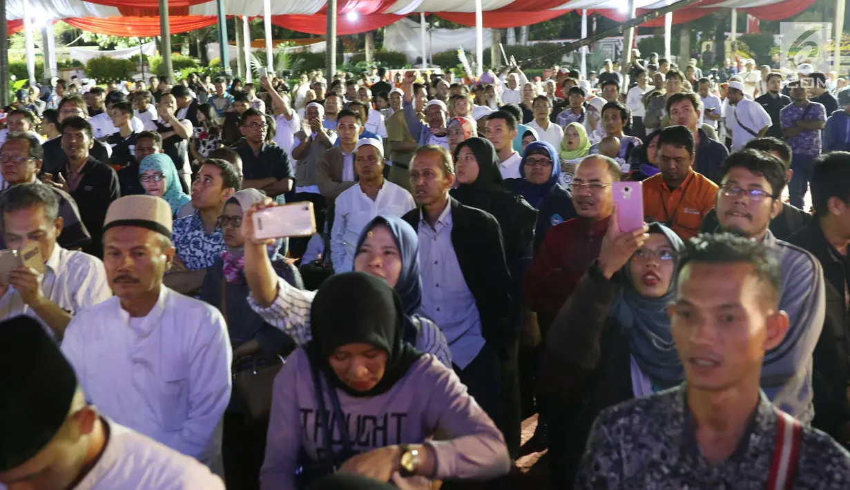 Warga menyaksikan pidato Gubernur DKI Jakarta Anies Baswedan di Balai Kota, Senin (16/10). Anies Baswedan berpidato untuk pertama kalinya sebagai Gubernur DKI Jakarta periode 2017-2022. (Liputan6.com/Faizal Fanani)