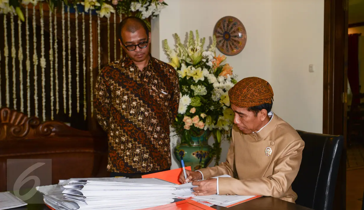 Presiden Jokowi (kanan) didampingi Sekretaris Kabinet Andi Widjajanto (kiri) ketika menandatangani sejumlah berkas saat berkantor di rumahnya di Jalan Kutai Utara RT.08/RW.07 Sumber, Solo, Jateng, Rabu (10/6/2015). (Liputan6.com/Faizal Fanani)