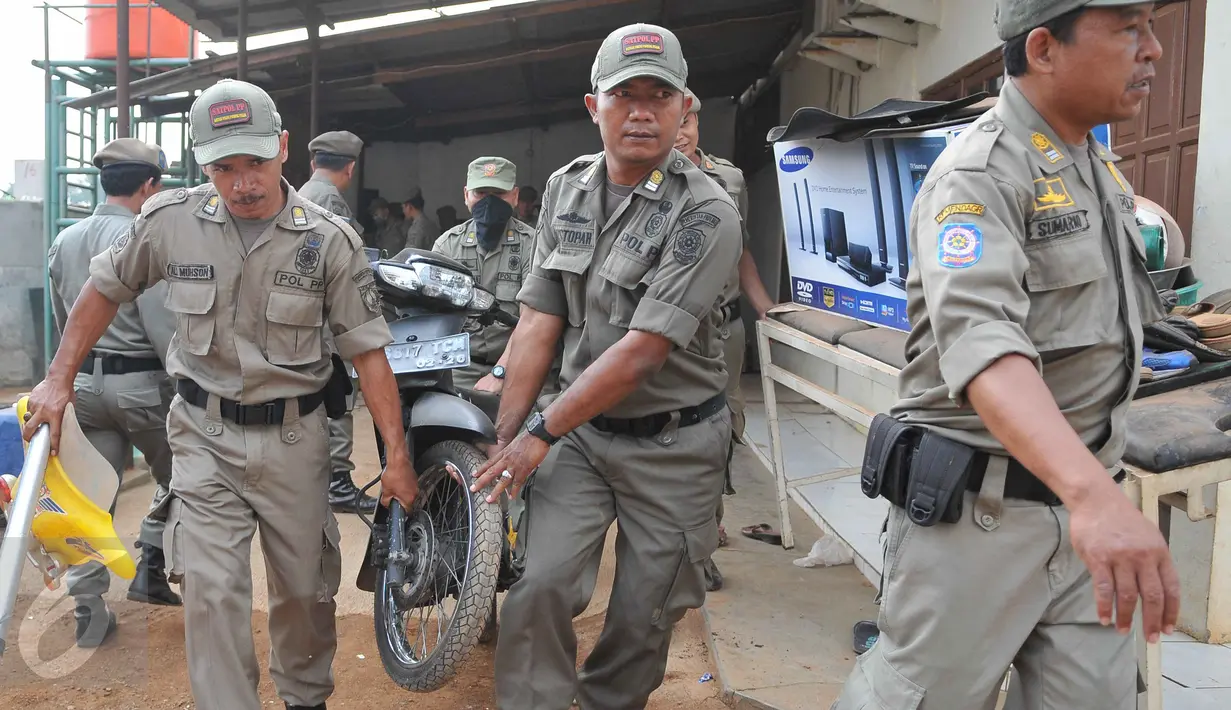 Petugas membantu warga untuk mengevakuasi barang saat pembongkaran bangunan di kawasan Pangkalan Jati, Bekasi, Jawa Barat, Kamis (8/10). Pembongkaran dilakukan untuk mempersiapkan lahan pembangunan Jalan Tol  Becakayu. (Liputan6.com/Gempur M Surya)