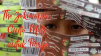 Seorang anak memegang tiket pertandingan saat pembagian untuk The Jakmania di Menteng, Jakarta (14/5/2017). (Bola.com/Nicklas Hanoatubun)