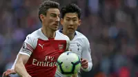 Bek Arsenal, Laurent Koscielny, berusaha melewati striker Tottenham, Son Heung-Min, pada laga Premier League di Stadion Wembley, London, Sabtu (2/3). Kedua klub bermain imbang 1-1. (AFP/Daniel Leal-Olivas)
