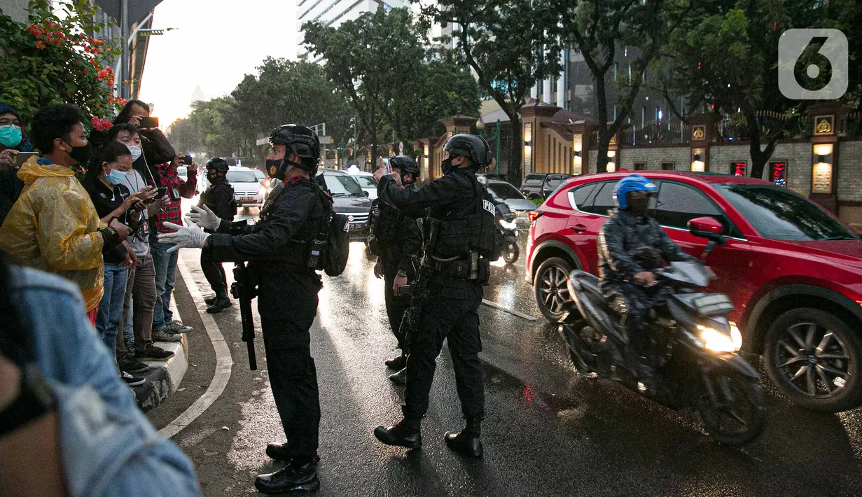 Polisi bersenjata lengkap meminta warga sekitar menjauh dari kawasan Mabes Polri Jakarta, Rabu (31/3/2021). Seorang terduga teroris diduga berupaya melakukan penyerangan ke area Mabes Polri hingga aksi baku tembak dengan polisi pun sempat terjadi. (Liputan6.com/Faizal Fanani)