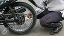 Petugas Dishub DKI Jakarta mengembosi motor yang nekat parkir liar di Jalan St.Senen, Jakarta Pusat, Selasa (29/3/2016). Kendaraan roda dua terparkir di bahu jalan ataupun trotoar langsung ditindak. (Liputan6.com/Yoppy Renato)