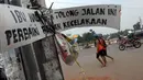 Sebuah papan terpasang di ruas jalan Raya Siliwangi Pamulang, Kota Tangerang Selatan (Tangsel),Banten, Kamis (12/5). Warga sekitar mengeluhkan lambatnya penyelesaian proyek pelebaran jalan yang menghubungkan Serpong-Pamulang. (Liputan6.com/Helmi Afandi)