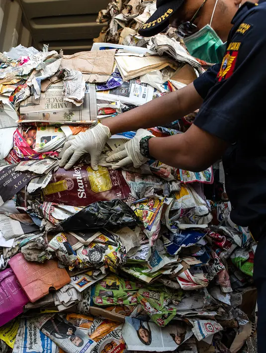 Petugas Bea Cukai Tanjung Perak memeriksa kontainer berisi sampah asal Australia di Pelabuhan Tanjung Perak, Surabaya, Jawa Timur, Selasa (9/7/2019). Kepala Kantor Bea Cukai Tanjung Perak Basuki Suryanto mengatakan penindakan dilakukan untuk melindungi masyarakat dari sampah B3. (JUNI KRISWANTO/AFP)