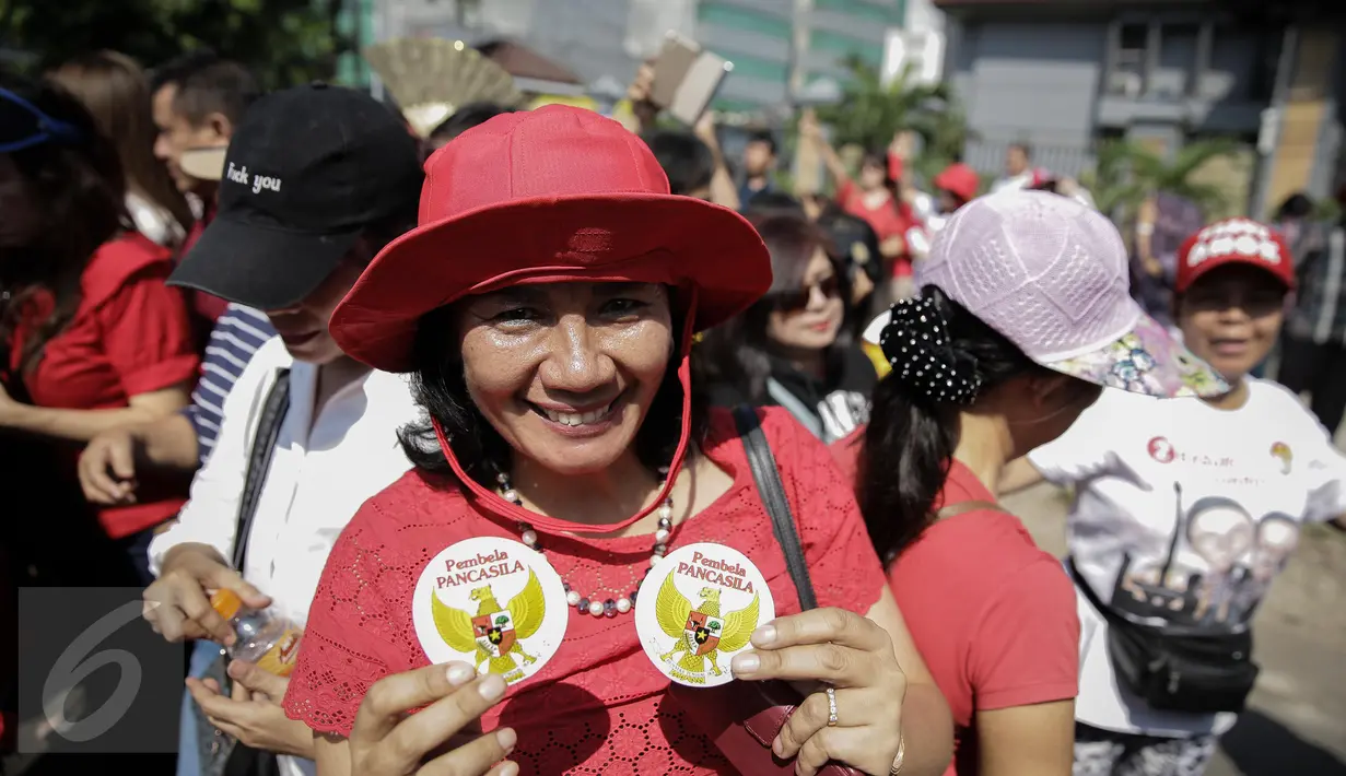 Pendukung Basuki Tjahaja Purnama atau Ahok menunjukkan pin "Pembela Pancasila" saat kembali menggelar aksi di depan Pengadilan Tinggi DKI Jakarta, Jumat (12/5). Massa menuntut agar penangguhan penahanan Ahok dikabulkan. (Liputan6.com/Faizal Fanani)