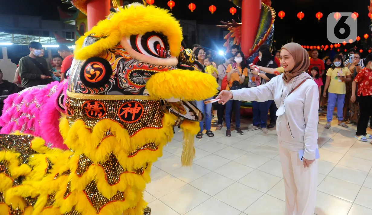Warga memberikan angpao kepada barongsai saat perayaan malam Tahun Baru Imlek 2574 di Vihara Kwan In Thang, Pondok Cabe, Tangerang Selatan, Banten, Sabtu (21/1/2023). Perayaan Imlek berlangsung semarak dengan adanya pertunjukan barongsai setelah sempat vakum selama 2 tahun akibat pandemi Covid-19. (merdeka.com/Arie Basuki)