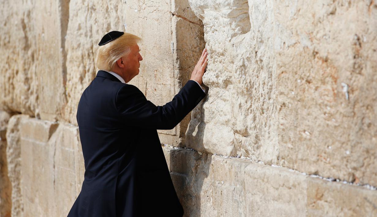 Presiden AS Donald Trump menyentuh Tembok Ratapan saat mengunjungi tempat suci milik kaum Yahudi itu di Yerusalem, Senin (22/5). Ini adalah pertama kalinya Presiden Amerika Serikat mengunjungi dan berdoa di lokasi tersebut. (AP Photo/Evan Vucci)
