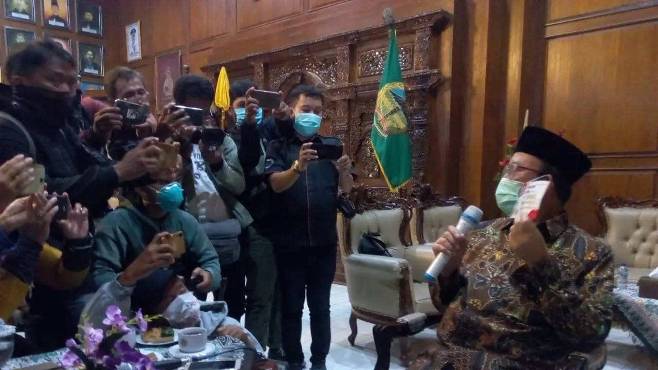 Bupati Banyumas menunjukkan contoh stiker sosialisasi pencegahan virus corona yang akan dicetak hingga 800 ribu lembar saat konferensi pers di Ruang Joko Kaiman, Senin (16/3)/2020). (Foto: Liputan6.com/Rudal Afgani Dirgantara)