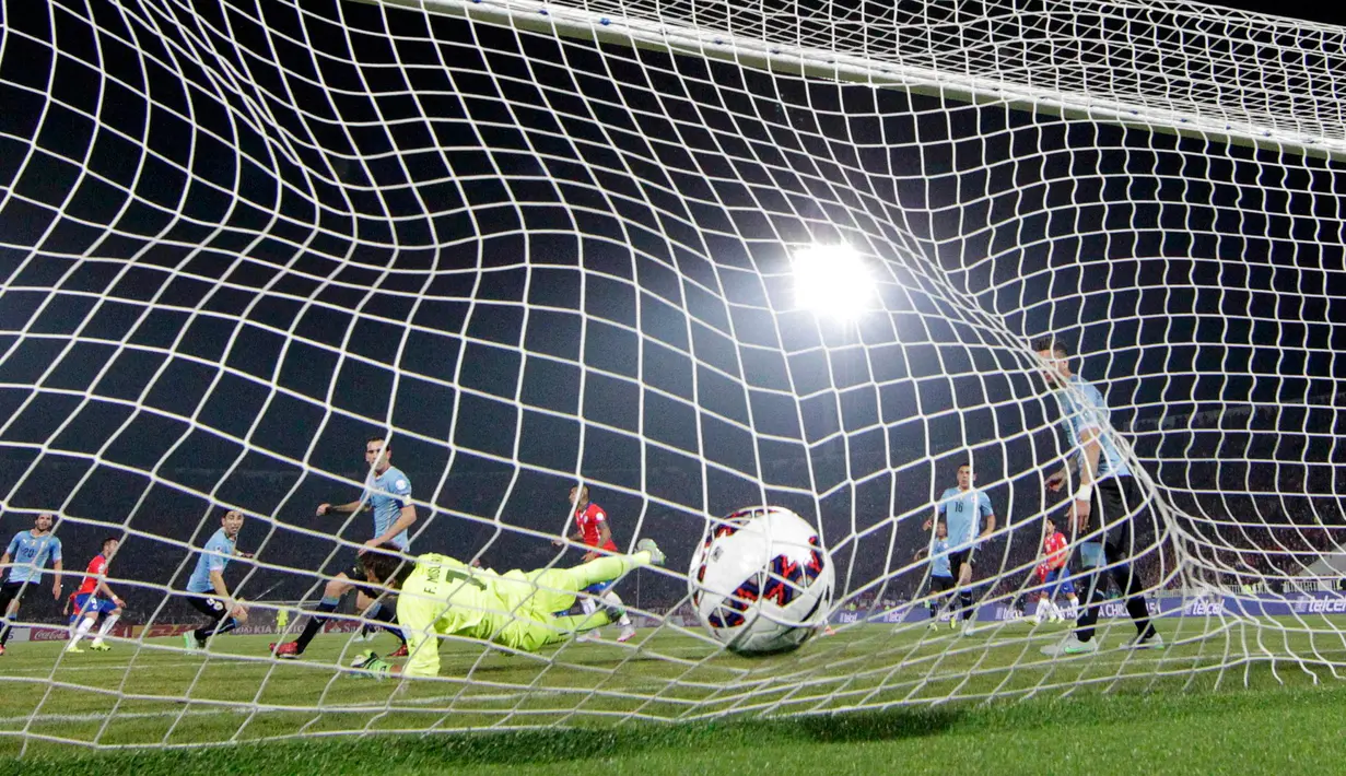 Kiper Uruguay, Fernando Muslera gagal mengahalau tendangan bek Chile, Mauricio Isla di perempat final Copa Amerika 2015 di National Stadium, Santiago, Chile, (25/6/2015). Chile melaju ke semifinal usai mengalahkan Uruguay 1-0. (REUTERS/Henry Romero)