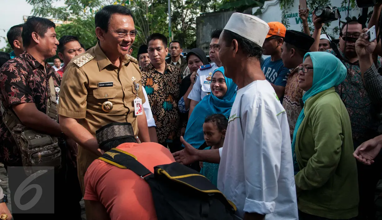 Warga bersalaman dengan Gubernur DKI Jakarta Basuki T Purnama di makam Habib Hasan Al Haddad, Koja, Jakarta Utara, Selasa (14/2). Pemerintah DKI Jakarta berencana melakukan penataan lahan pemakaman tersebut. (Liputan6.com/Gempur M Surya)