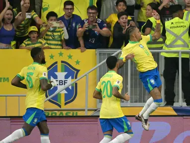 Penyerang Brasil, Raphinha (kanan) merayakan gol dengan rekan setimnya pada pertandingan sepak bola kualifikasi Piala Dunia FIFA 2026 zona Amerika Selatan melawan dan Peru di stadion Mane Garrincha, Brasilia, Selasa 15 Oktober 2024 atau Rabu (16/10/2024) pagi WIB. (NELSON ALMEIDA/AFP)