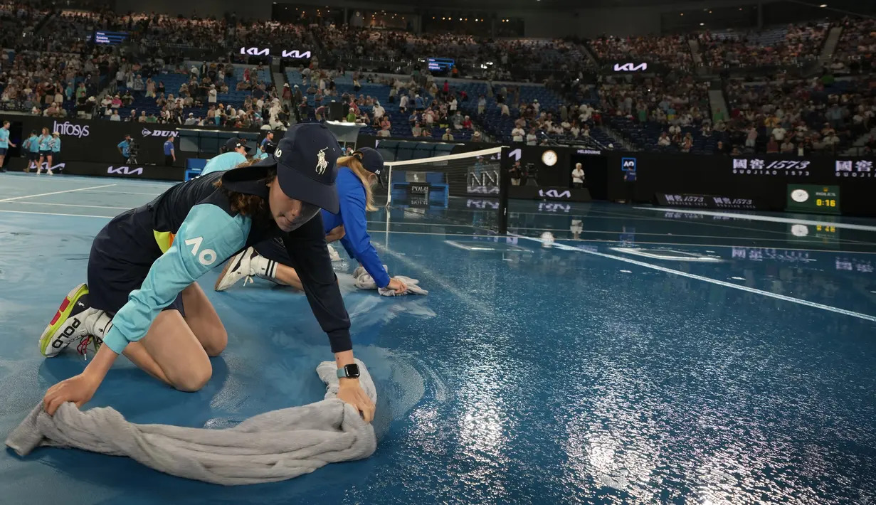 Para ball boy mengeringkan lapangan saat hujan menunda pertandingan perempat final kejuaraan tenis Australia Open 2023 di Melbourne, Selasa (24/1/2023). Sejumlah laga di lapangan luar ruang terpaksa dihentikan saat hujan mengguyur termasuk laga perempat final tunggal putri antara petenis Latvia Jelena Ostapenko melawan petenis Kazakhstan Elena Rybakina. (AP Photo/Aaron Favila)