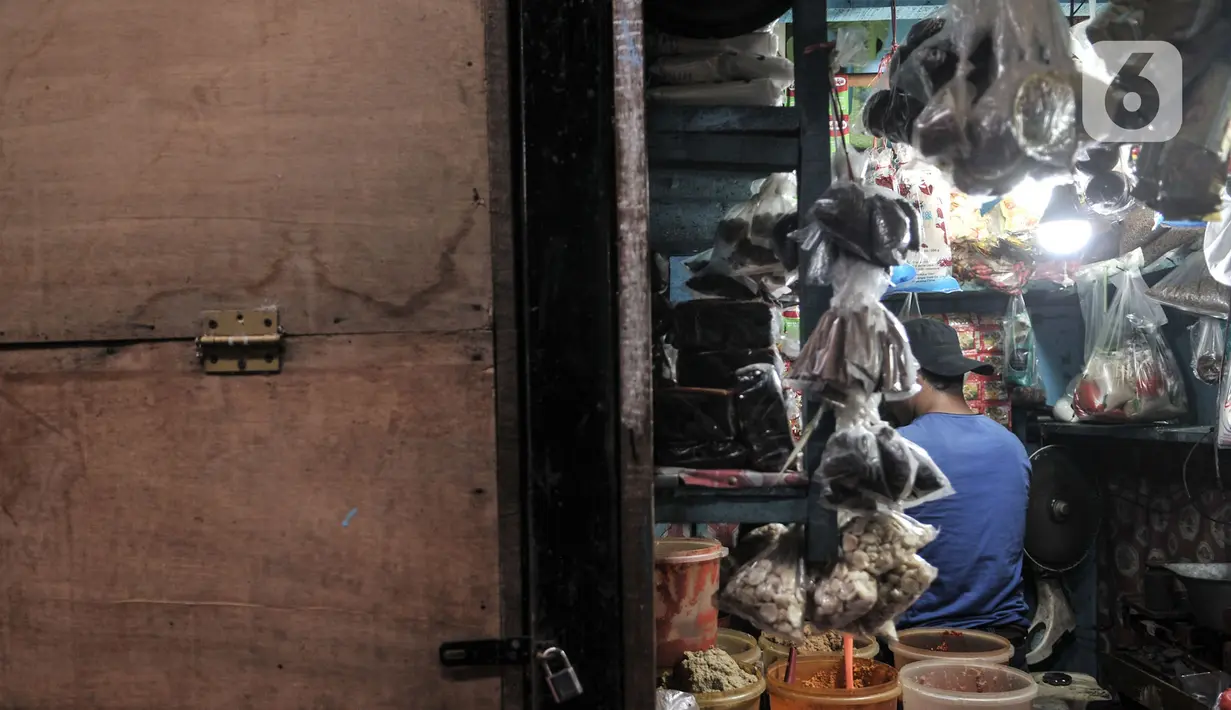 Pengunjung melintasi deretan kios pedagan yang tutup di Pasar Sumur Batu, Kemayoran, Jakarta, Rabu (8/7/2020). Dari 156 pedagang, hingga saat ini baru 30 orang yang mengikuti tes usap. (merdeka.com/Iqbal S. Nugroho)