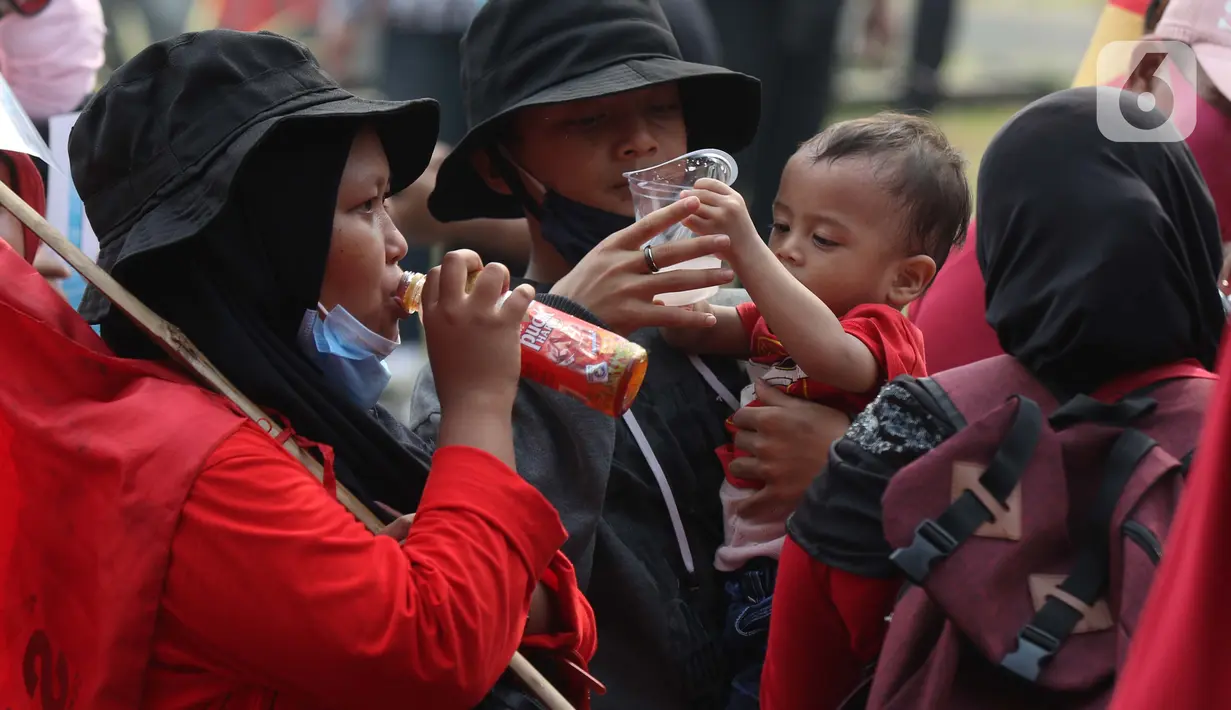 Seorang anak digendong terlihat dalam aksi unjuk rasa menolak UU Omnibus Law Cipta Kerja di Kawasan Patung Kuda, Jakarta, Jumat (16/10/2020). Meski sudah ada imbauan untuk tidak membawa anak-anak dalam aksi unjuk rasa namun sejumlah orang tua tetap menyertakan. (Liputan6.com/Helmi Fithriansyah)